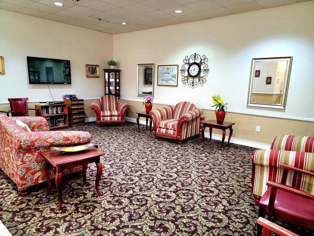 Television room with comfortable seating and a wall-mounted TV at Sunny Hills in Homestead